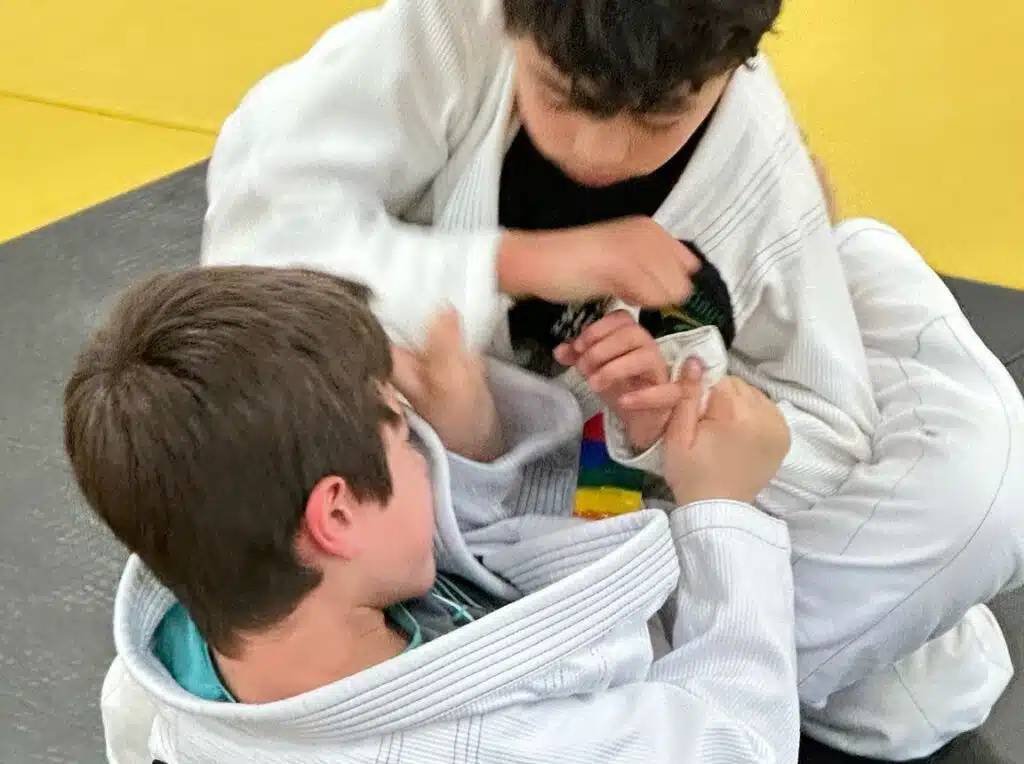 Children practicing a technique together during Kids Jiu Jitsu in Portland at Five Rings Jiu Jitsu Portland