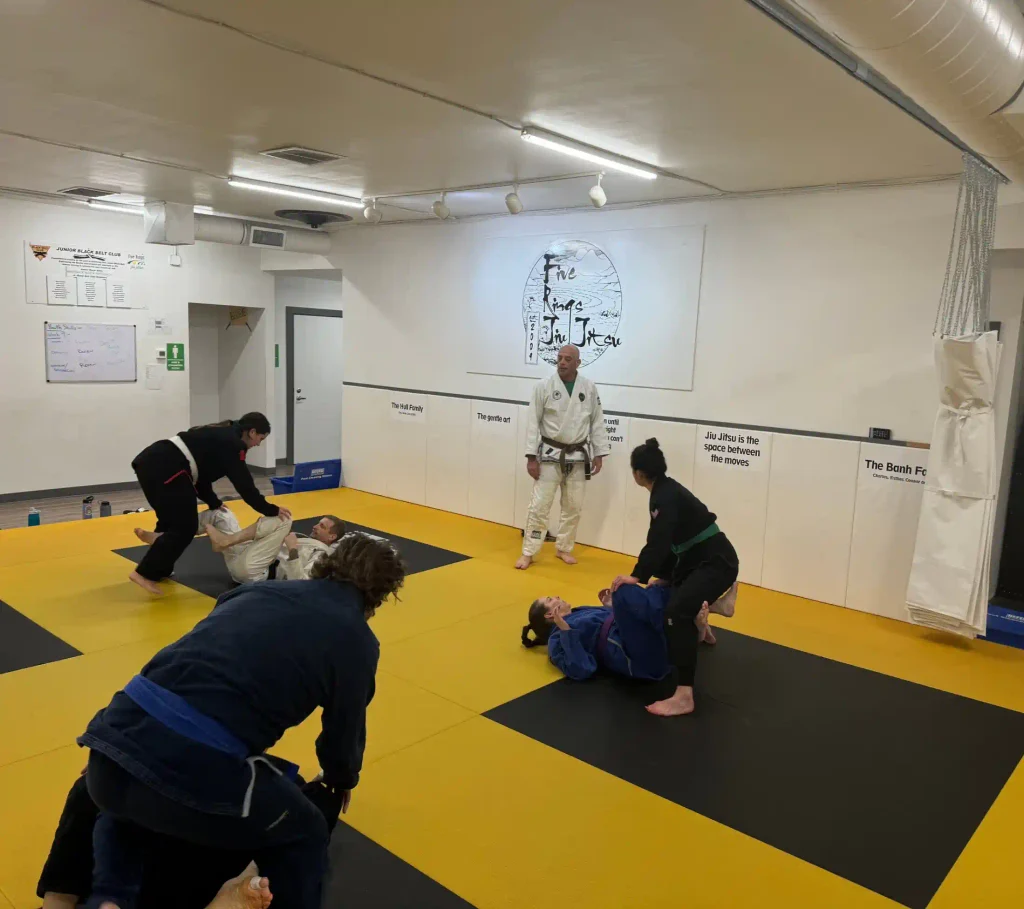 Brazilian Jiu-Jitsu instructor teaching beginners how to escape side control using frames and hip movement.