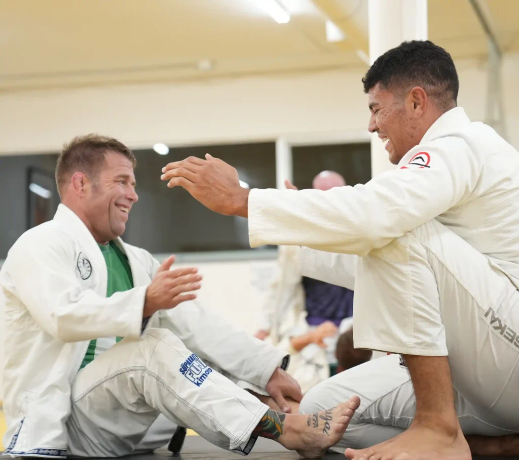 Students practicing beginner Brazilian Jiu-Jitsu escapes with instructor supervision at a Portland martial arts academy.